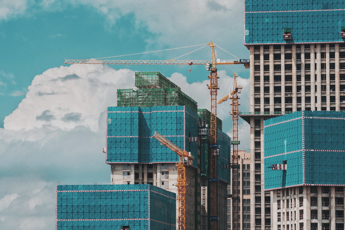 a group of tall buildings under a cloudy blue sky