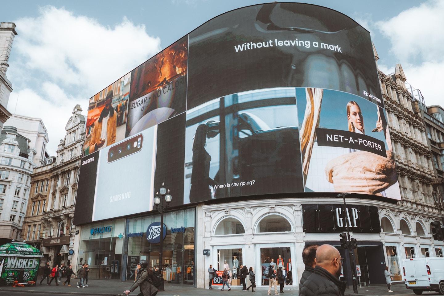 Large curved building with many digital billboards