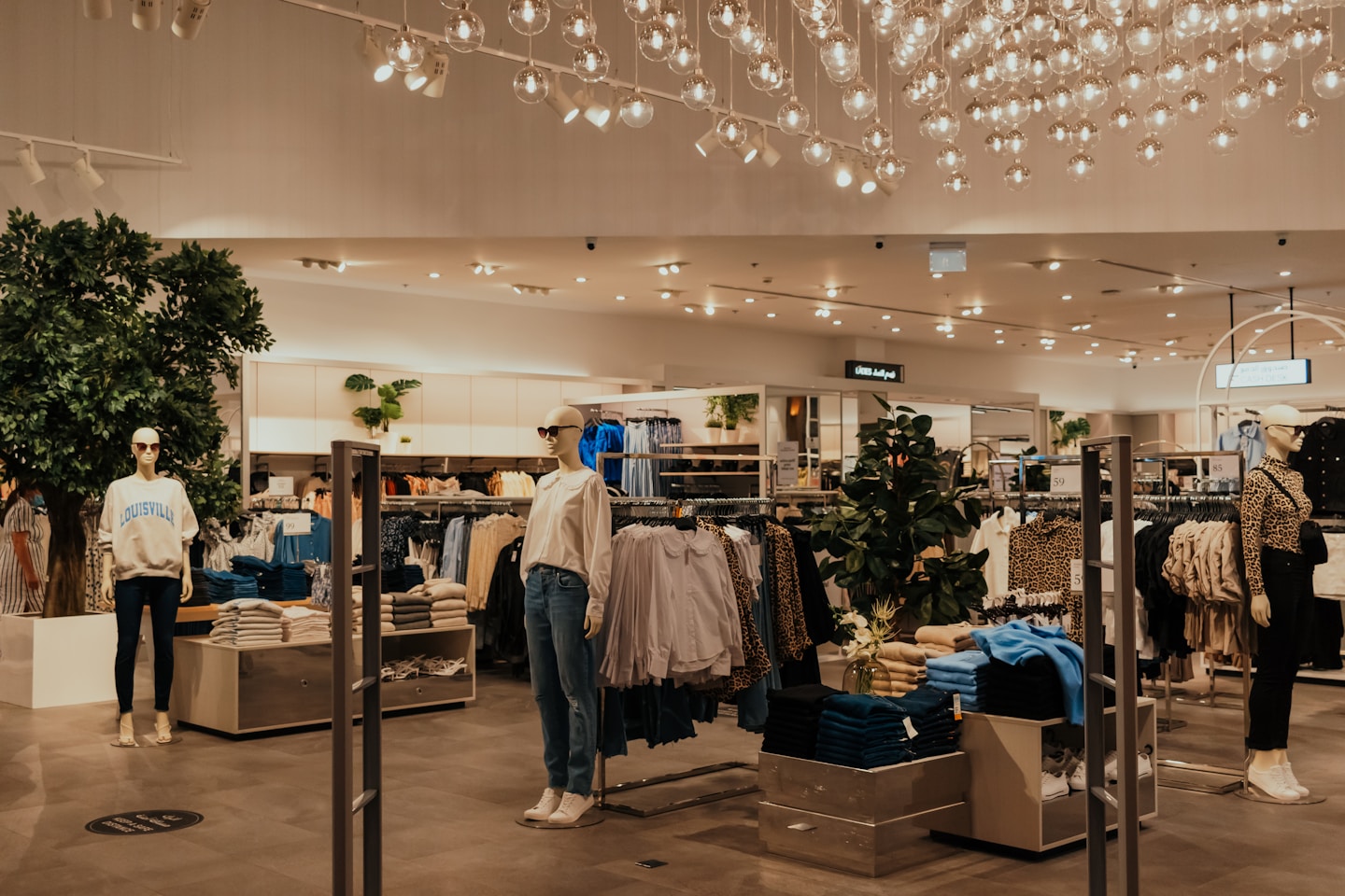 A retail shopping store with a lot of clothing and manikins